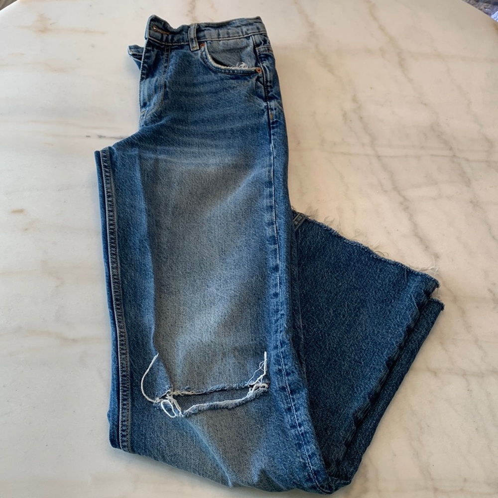 ZARA jeans high waisted, been used once. Zip up and raw hem, one ripped knee.